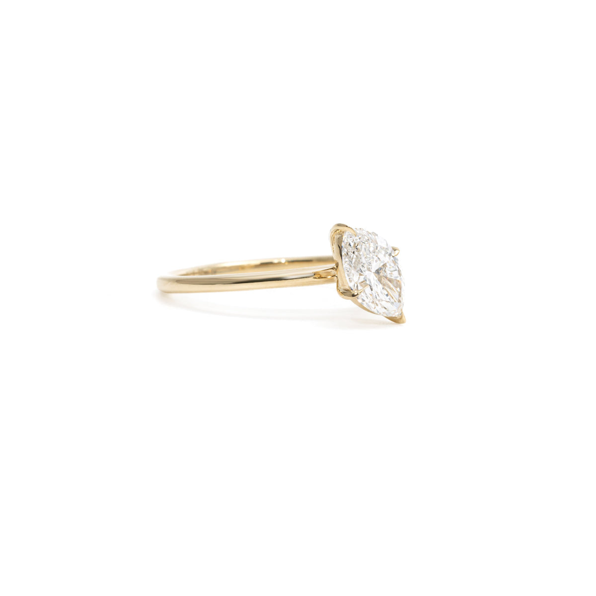 Side profile showing tilted oval cut diamond with secure prong setting and tapered band