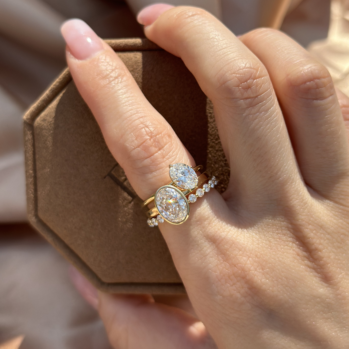 Stacked look featuring Aria tilted oval diamond solitaire ring paired with a bezel-set ring