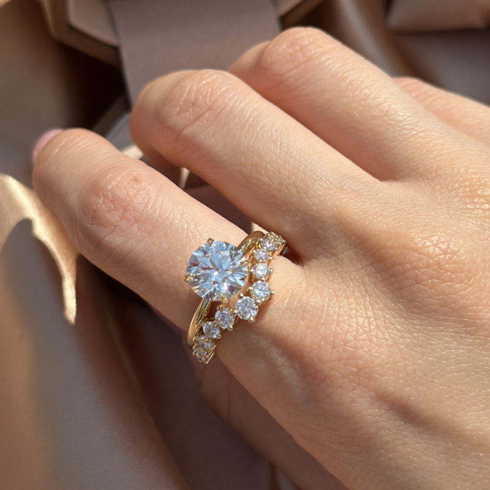 Stacked ring look featuring a solitaire round diamond ring and a delicate curved wedding band