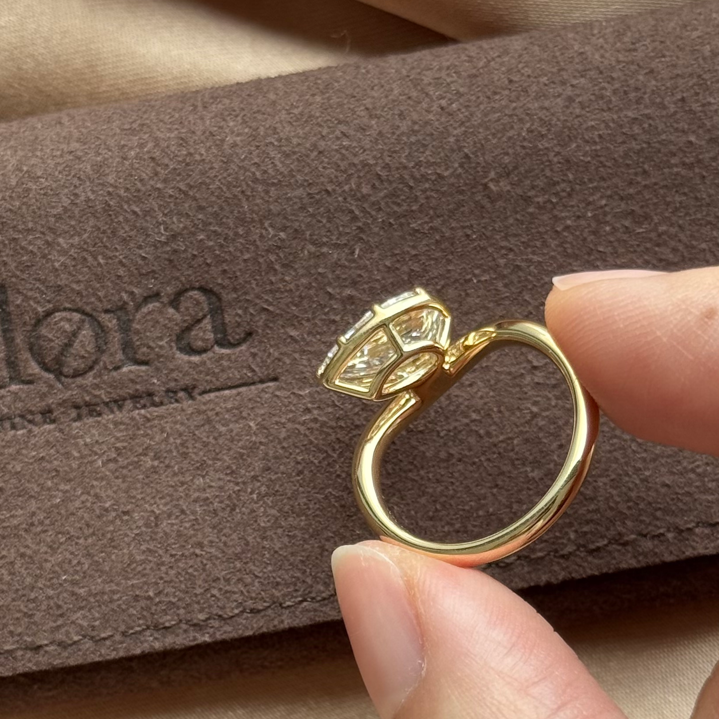 Wave-Pear Cut Yellow Gold Lab Grown Diamond Engagement Ring held by a person, showcasing its elegant design.