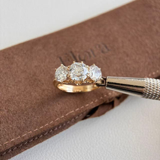 Marcella-1.5ct Antique Cut Lab Grown Diamond Trilogy Engagement Ring on brown fabric background.