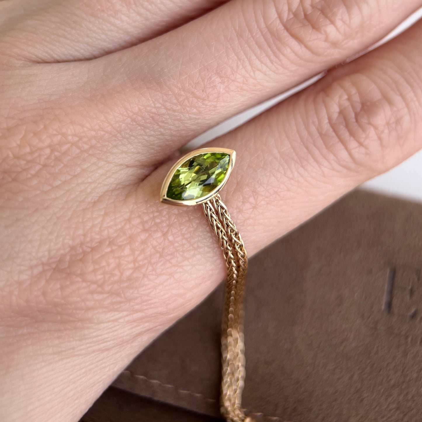 Faith-Marquise Cut Natural Peridot Gemstone Chain Ring worn on a hand, showcasing the marquise cut peridot in yellow gold.
